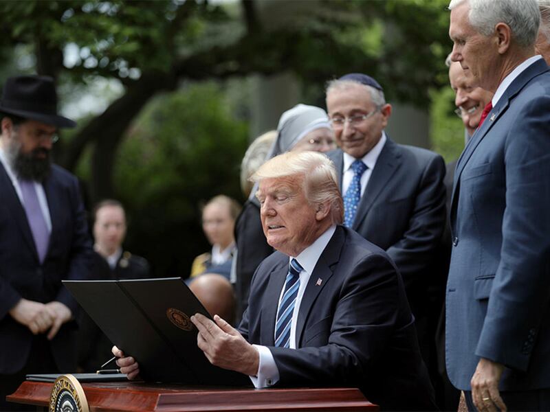 President Trump prepares to sign the Executive Order on Promoting Free Speech and Religious Liberty during the National Day of Prayer event at the Rose Garden of the White House on May 4, 2017.