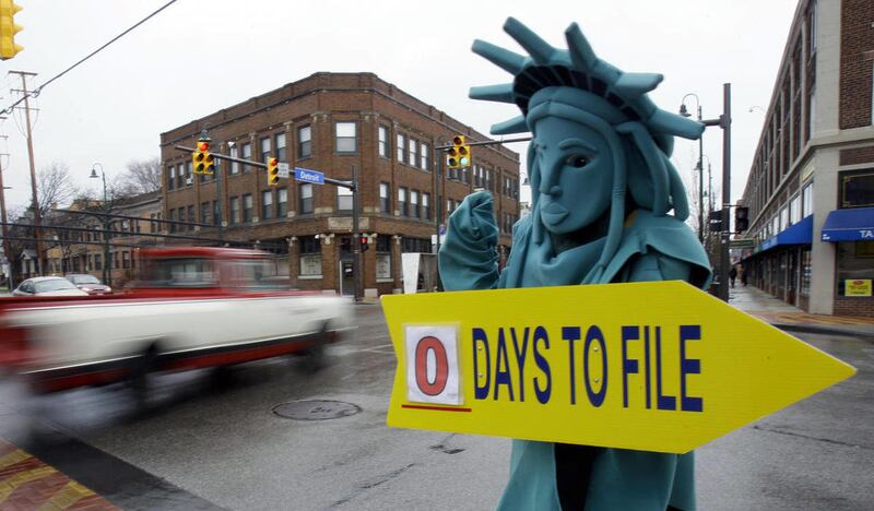 FILE-In this Monday, April 18, 2011, file photo, Max Martinez, dressed as the Statue of Liberty, tries to alert motorists on the final day to file taxes.
