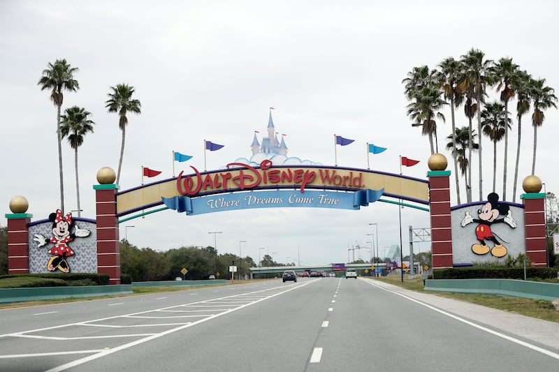 FILE - In this Monday, March 16, 2020, file photo, the road to the entrance of Walt Disney World has few cars, in Lake Buena Vista, Fla. Two more unions have reached agreements with Walt Disney World over furloughs caused by the theme park resort’s closure during the new coronavirus outbreak. The agreements reached late Friday, April 10, apply to security guards and workers involved in facilities and operations. (AP Photo/John Raoux, File)
