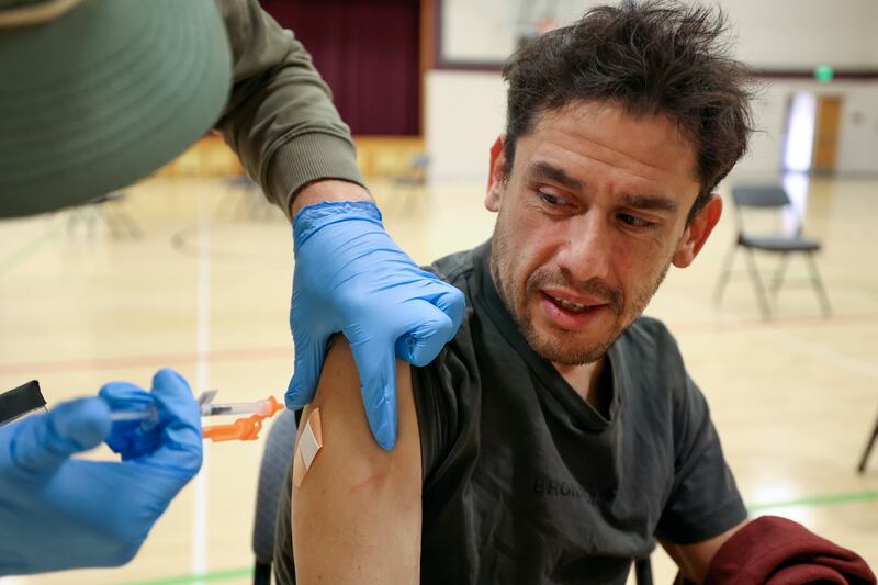 Jesus Hernandez gets a Moderna COVID-19 booster shot at the Sanderson Community Center in Taylorsville.