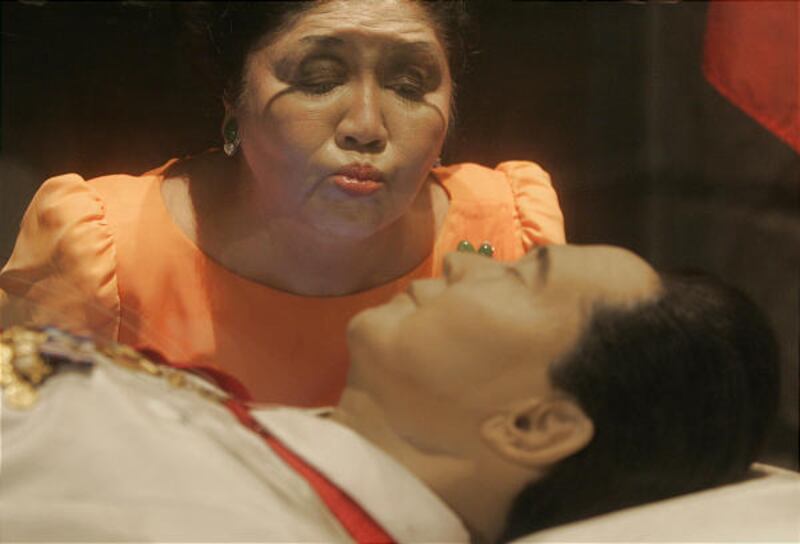 Imelda Marcos kisses the glass coffin of her husband, the late strongman Ferdinand Marcos, before she starts her motorcade campaign in Batac, Philippines, on Friday.