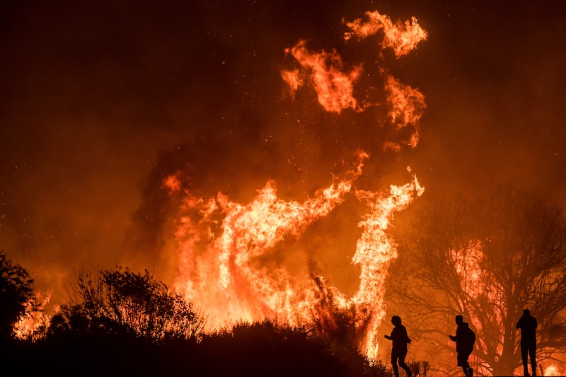 Motorists on Highway 101 watch flames from the Thomas fire leap above the roadway north of Ventura, Calif., on Wednesday, Dec. 6, 2017. As many as five fires have closed highways, schools and museums, shut down production of TV series and cast a hazardous