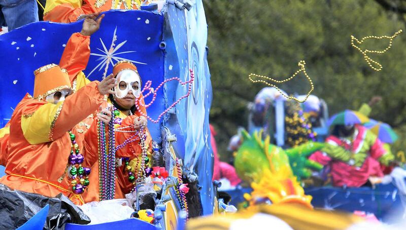 Riders on float no. 9 Libra toss to the crowds on Napoleon Avenue during the Krewe of New Orleans Most Talked Of Club (NOMTOC) parade Sunday, Feb. 19,2012 in New Orleans. NOMTOC, which usually rolls through the streets of Algiers on the West Bank, was mov