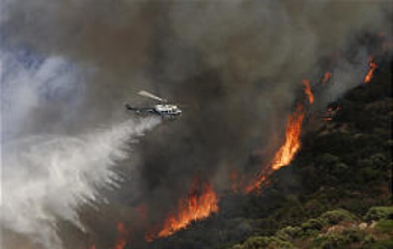 A San Diego sheriff's helicopter drops a load of water on the Cleveland National Forest fire that grew to 6,600 acres.
