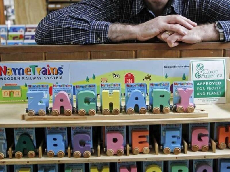 In this Friday, Feb. 22, 2013, photo, Mike Rainville poses with some of his products at the Maple Landmark Woodcraft factory in Middlebury, Vt. Rainville works with multiple generations of his family at the factory. Experts say family businesses are more