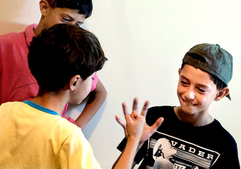 Abdallah watches as Eslam and Fahed Hamad play a Syrian game that is similar to America's rock, paper, scissors to see who gets the top bunk bed as Catholic Community Services employees moved in new beds for the family in South Salt Lake on Friday, June 9