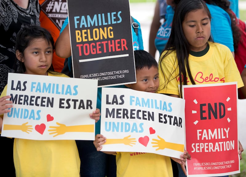 FILE - In this June 1, 2018, file photo, children hold signs during a demonstration in front of the Immigration and Customs Enforcement offices in Miramar, Fla. The Trump administration's move to separate immigrant parents from their children on the U.S.-