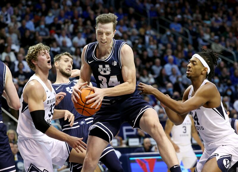 Utah State Aggies forward Justin Bean (34) rips down a rebound as BYU and Utah State play.
