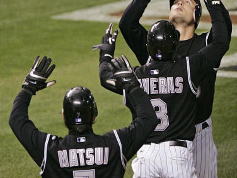 Colorado Rockies' Matt Holliday is congratulated by Willy Taveras (3) and Kazuo Matsui (7) after hitting a three-run home run during the fourth inning in Game 4 of the NLCS against the Arizona Diamondbacks in Denver, Monday.