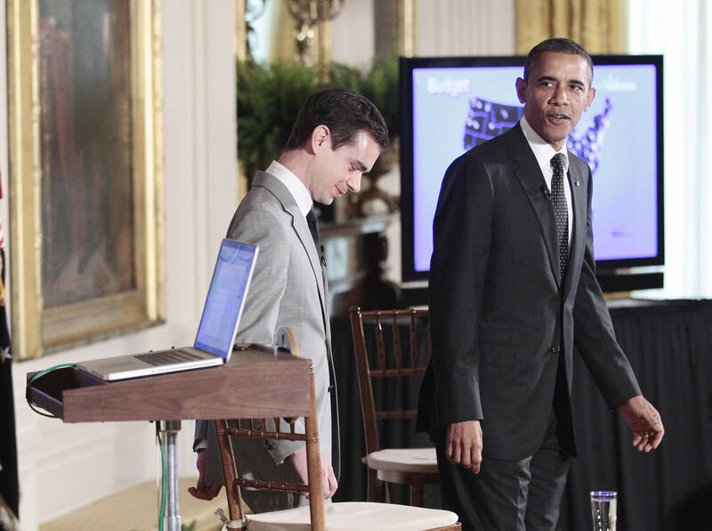 President Barack Obama walks to his seat after using a Macbook laptop during his live-tweet during the first ever Twitter Town Hall, Wednesday, July 6, 2011, in the East Room of the White House in Washington.