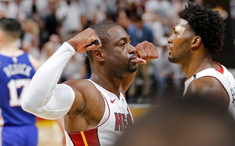 Miami Heat guard Dwyane Wade, left, reacts after his score late in the fourth quarter against the Philadelphia 76ers in Game 4 of a first-round NBA basketball playoff series, Saturday, April 21, 2018, in Miami. Heat forward Justise Winslow, right, looks o