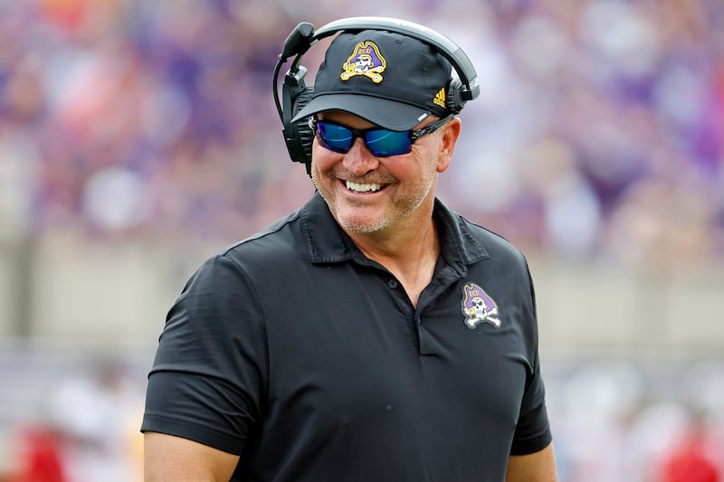East Carolina coach Mike Houston jokes with an official during game against North Carolina State in Greenville, N.C.