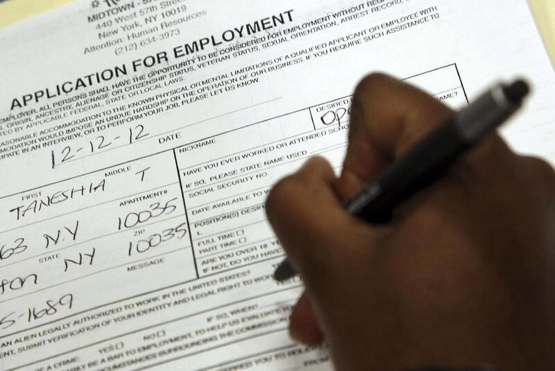 In this Wednesday, Dec. 12 2012 photo, Taneshia Wright, of Manhattan, fills out a job application during a job fair in New York. U.S. employers added 162,000 jobs in July, the fewest since March. But the gains were enough to lower the unemployment rate to