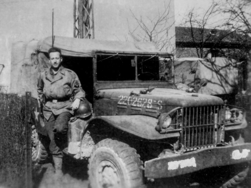 Staff Sgt. Stanley Nance, who served in the once-secret 23rd Headquarters Special Troops, a unit also known as the Ghost Army, stands alongside his radio vehicle, which he named the "Kilowatt Kommand," circa 1945.