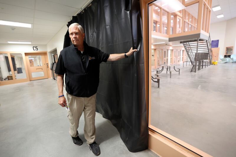 Steve Turley, Utah Department of Corrections special projects director, shows how a curtain will provide privacy for female inmates and create a visual barrier between males and females in the new Utah State Correctional Facility in Salt Lake City on Thursday, June 30.
