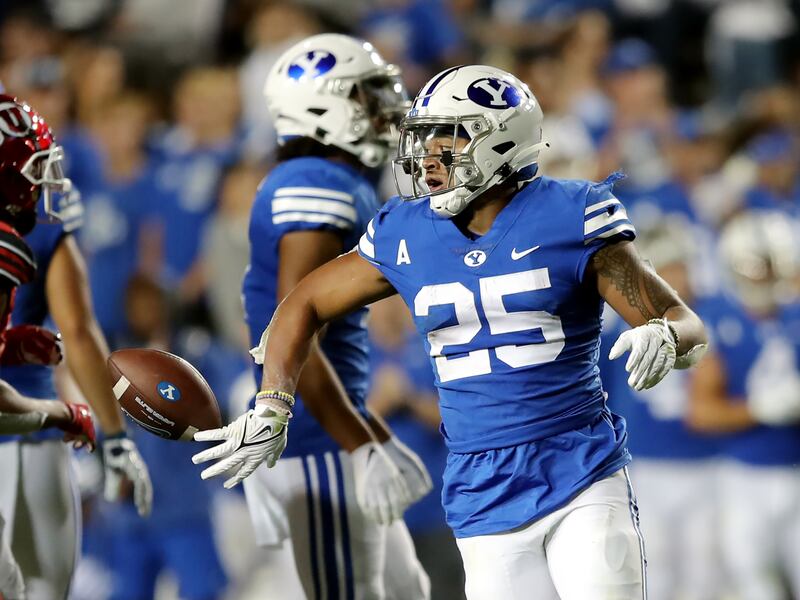 BYU running back Tyler Allgeier (25) flips the ball away after a run during a 2021 game against Utah at LaVell Edwards Stadium.