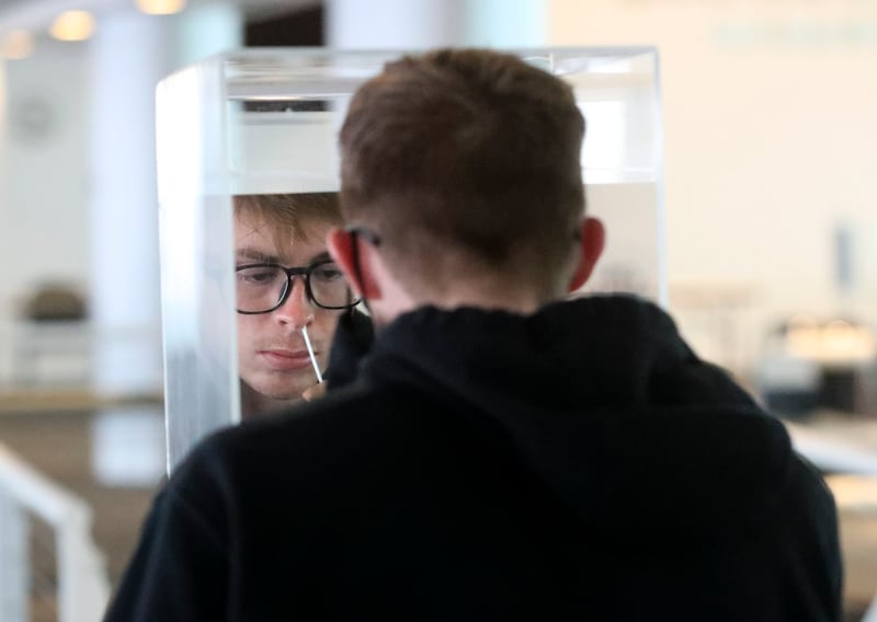 University of Utah student Wil Thompson swabs his nostril for a rapid COVID-19 test.