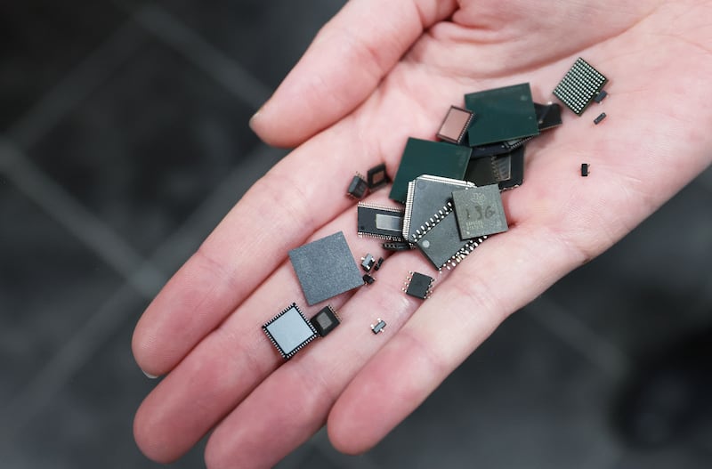 Tiny chips are held at Texas Instruments’ newly renovated microchip fabrication plant in Lehi.