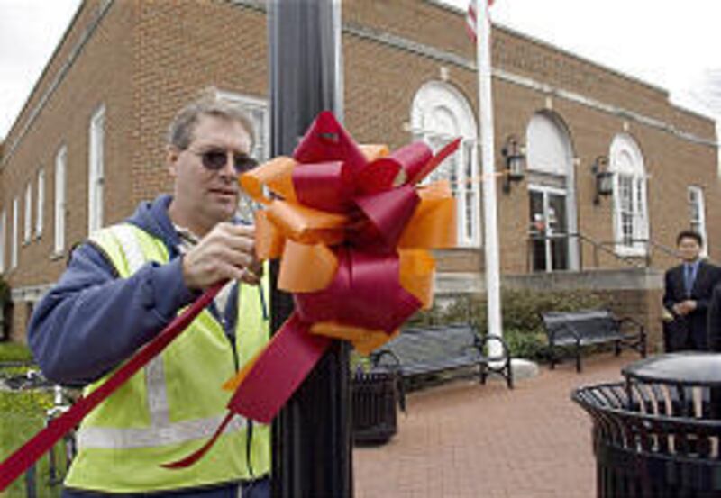 City worker Bobby Gravely ties a bow with the Virginia Tech University school colors onto a pole in front of the US Post Office in Blacksburg, where Cho Seung-Hui mailed a package to NBC News.