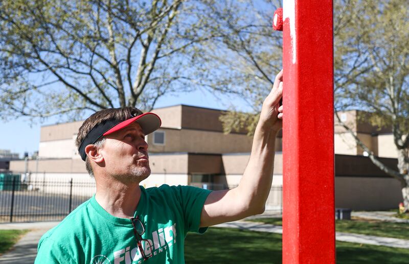 West High School Principal Ford White paints alongside volunteers from Fidelity Investments at the Salt Lake City school on April 27, 2019.