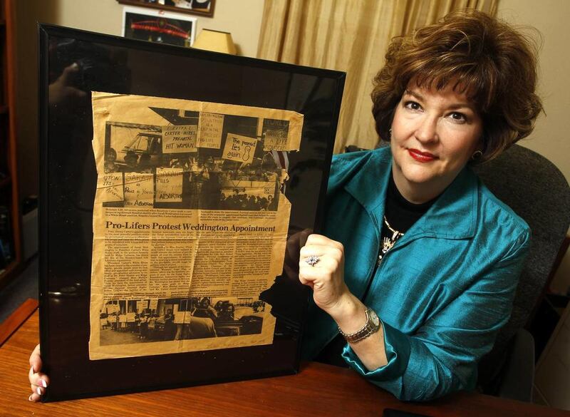 Kyleen Wright, president of Texans for Life Coalition, holds a framed newspaper clipping in which she appears in a photo taken during a protest when she was a teenager. The photo hangs in her office Thursday, Nov. 6, 2014.