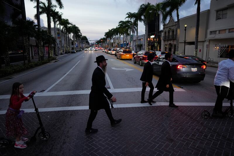 Jewish men and boys walk to synagogue for Shabbat service, in Miami Beach, Fla., Friday, Dec. 1, 2023.