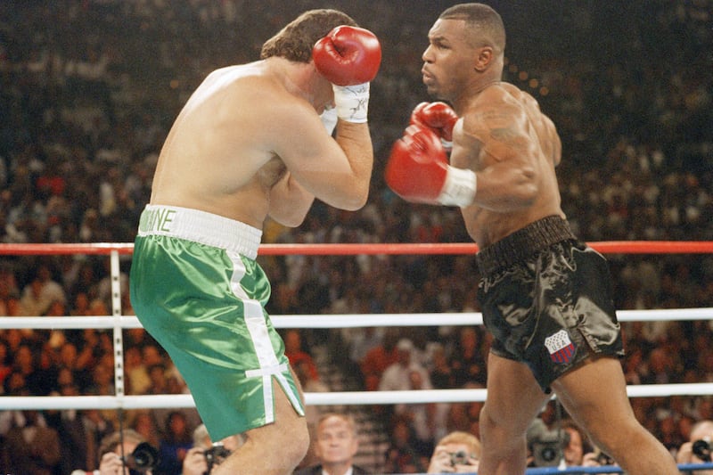 Peter McNeeley covers up as Mike Tyson leans toward him during first round of fight at MGM Grand Hotel in Las Vegas, Saturday, Aug. 19, 1995. Fight was stopped in first round, with Tyson winning.