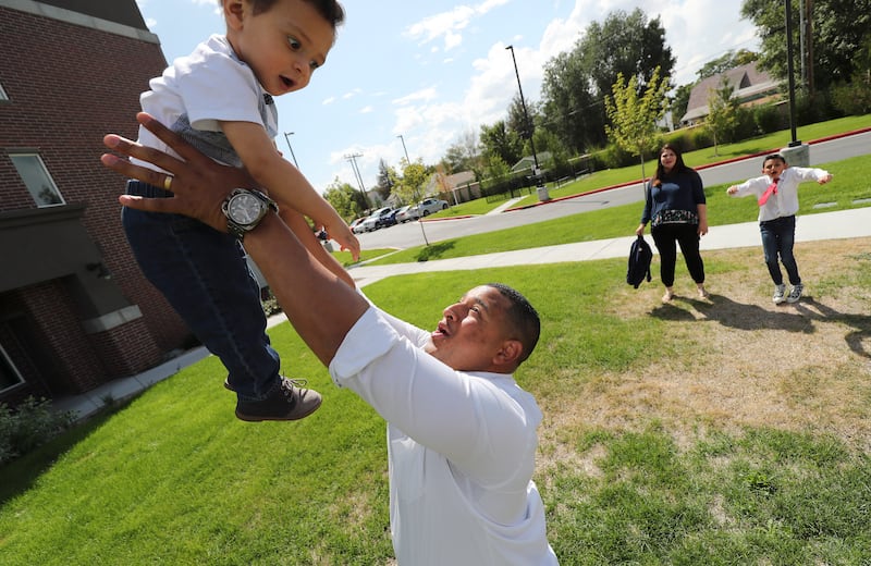 Carlos Moreno tosses his son Carlos Rodrigo as his wife, Norbelys, and son Carlos Isaias watch in Midvale.
