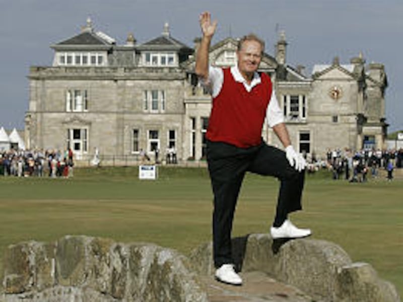 Golf legend Jack Nicklaus waves from the Swilcan Bridge at the British Open Friday as he makes his way to complete his final round of competitive golf.
