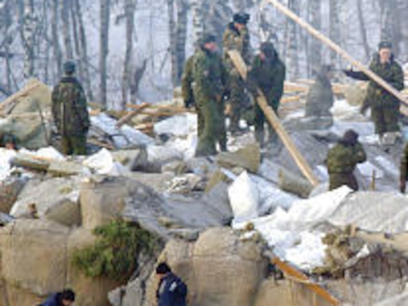 Rescue workers pick through the rubble of Transvaal Park in Moscow on Sunday. At least 25 people were killed, and 17 remain missing.<BR>