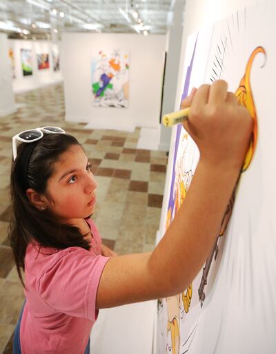 Ellie Quintana concentrates on her painting as parents and kids enjoy coloring the different art pieces at the Woodbury Art Museum's "Heroes and Villains: How Mythology Made Comics" exhibition at University Mall in Orem on Tuesday, Aug. 14, 2018.