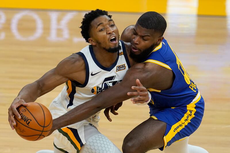 Utah Jazz guard Donovan Mitchell, left, is defended by Golden State Warriors forward Eric Paschall, right