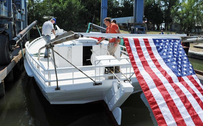 Just seconds after their skipjack, Ida May, is lowered into the water a Scott's Cove Marina in Chance, Md., owners and brothers Elbert, left, and Gordon Gladden check the vessel for leaks.