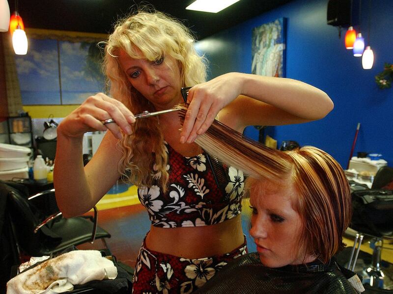 At right, Shona Barnthouse has her hair colored and cut by Juli Memmot (left) at Bikini Cuts in Sandy, Utah, November 11, 2003.