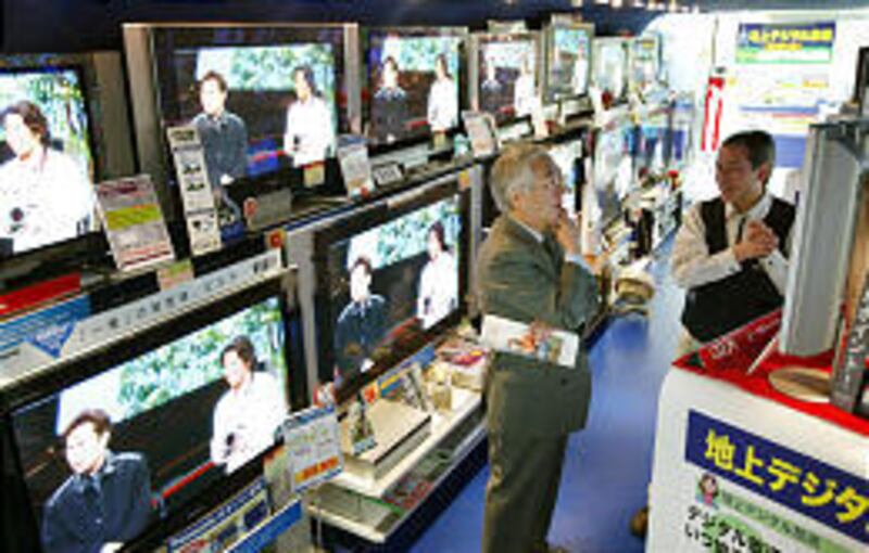 A Japanese shopper listens while a clerk explains digital TV in Tokyo.
