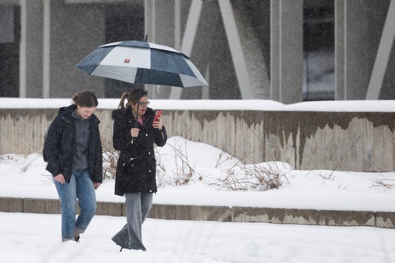 Assistant professor Anna Hodgson and University of Utah student Aubree Berrett walk through the snow at the University of Utah campus on April 4, 2023.