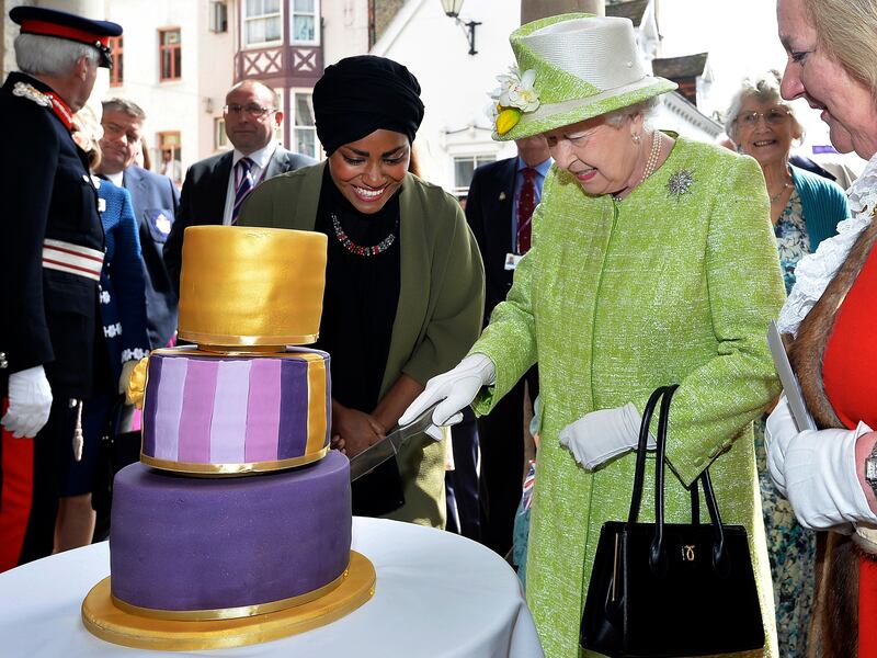 Britain’s Queen Elizabeth II cuts into a birthday cake baked by Nadiya Hussain in England on April 21, 2016.