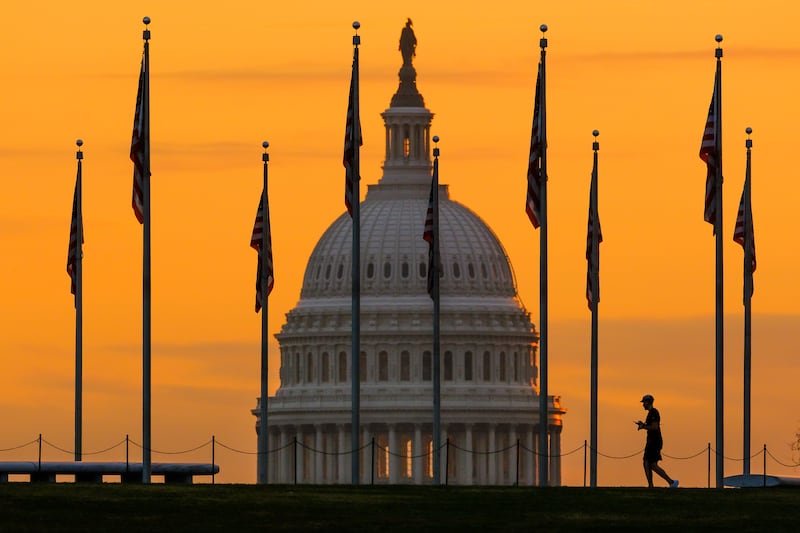 An early morning pedestrian is silhouetted against sunrise as he walks in Washington on Nov. 7, 2022.
