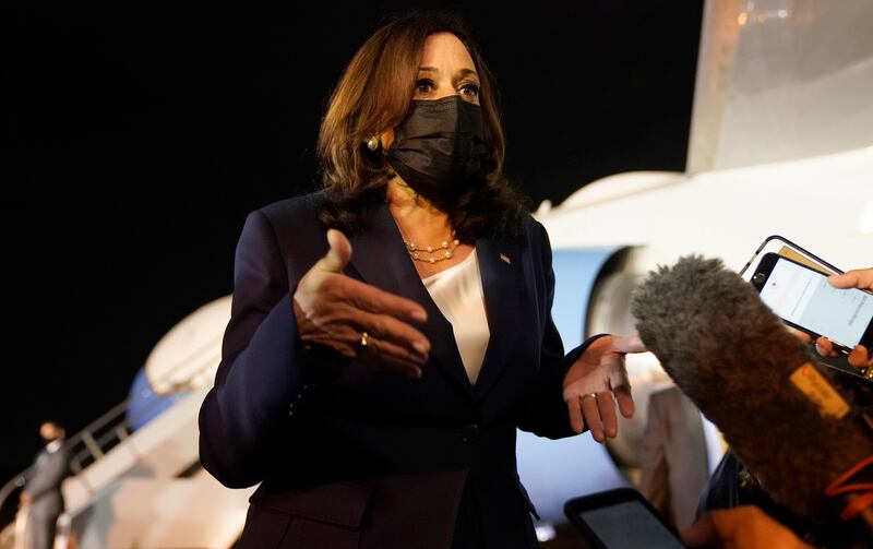 Vice President Kamala Harris talks to the press gathered under the wing of Air Force Two.