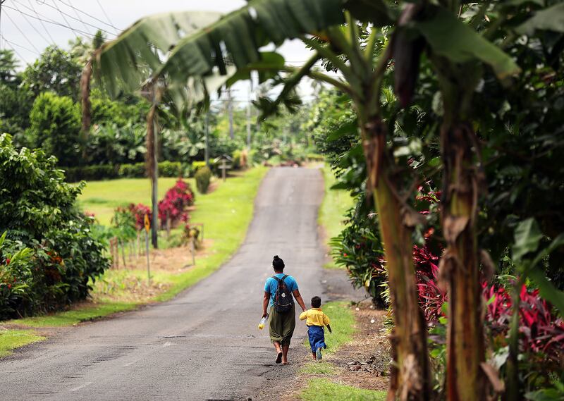 Fa'amele Fa'atuai makes the hourlong walk home with her son Lupi following activities at Foundational Learning preschool at the Siumu Ward in Siumu, Samoa, on Thursday, May 16, 2019.