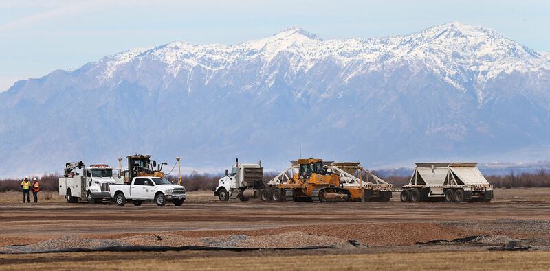 Trucks haul fill into the new prison site on the west side of Salt Lake City on Wednesday, Jan. 31, 2018.