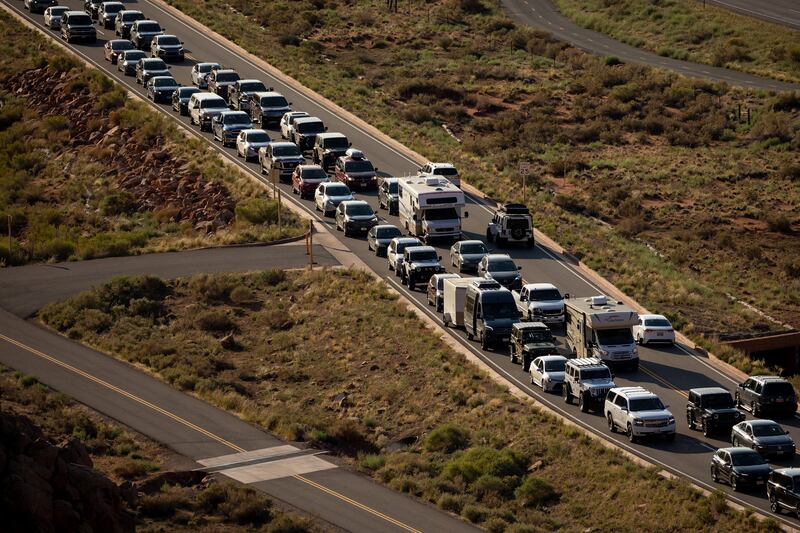 The entrance road to Arches National Park outside of Moab begins to back up with visitors on Sept. 19, 2021.