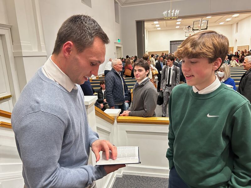 Britain Covey reads a scripture with a young man after speaking in a devotional in Philadelphia, Pennsylvania, in January 2025.
