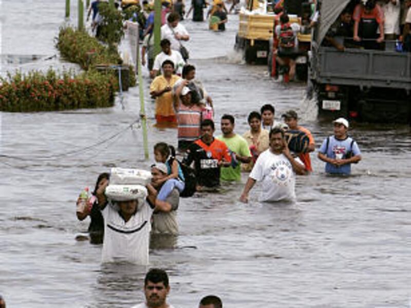 People evacuate a flooded area in Villahermosa, Mexico, Saturday. Many victims have spent the better part of a week trapped by the rising waters, and authorities warned of a possible health crisis and scattered reports of looting as supplies run out.