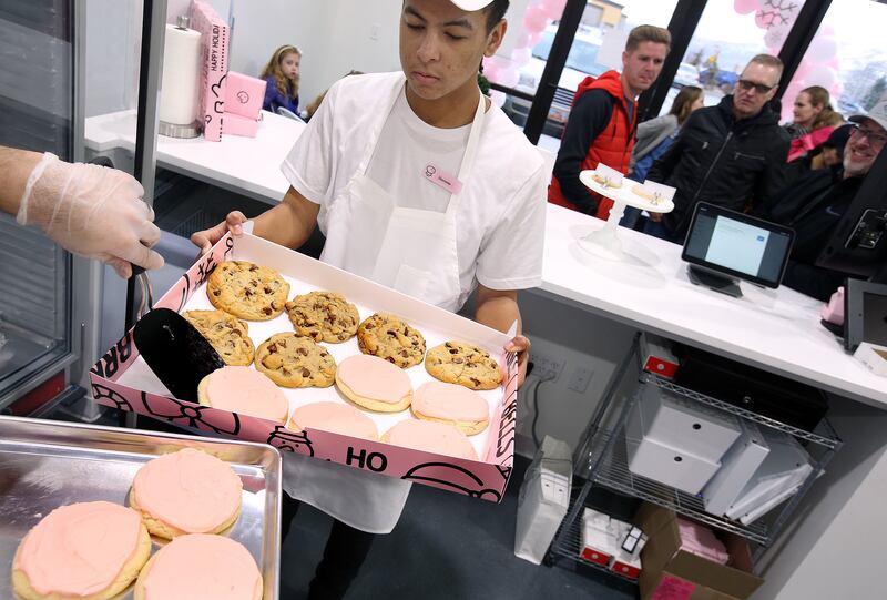 Deyonte Dennis prepares a party box of cookies for a customer at Crumbl in Lehi on Friday, Dec. 21, 2018.