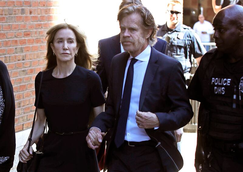 Felicity Huffman arrives at federal court with her husband William H. Macy for sentencing in a nationwide college admissions bribery scandal, Friday, Sept. 13, 2019, in Boston. (AP Photo/Elise Amendola)