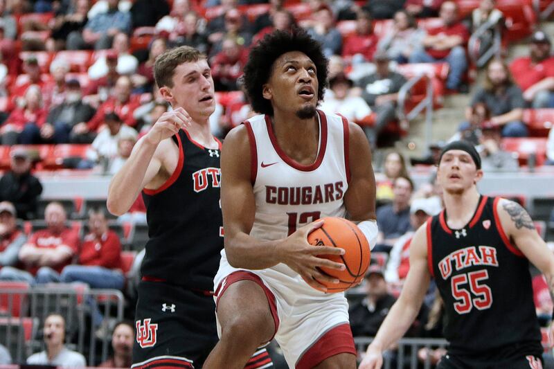 Washington State forward Isaac Jones eyes the basket, next to Utah forward Ben Carlson during the second half of an NCAA college basketball game Wednesday, Jan. 24, 2024, in Pullman, Wash.