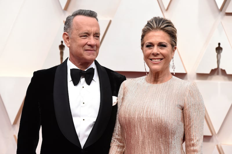 In this Feb. 9, 2020 file photo, Tom Hanks, left, and Rita Wilson arrive at the Oscars at the Dolby Theatre in Los Angeles. The couple have tested positive for the coronavirus, the actor said in a statement Wednesday, March 11. The 63-year-old actor said they will be “tested, observed and isolated for as long as public health and safety requires.” (Photo by Jordan Strauss/Invision/AP, File)
