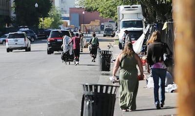 FILE - Homeless people leave the area around the Road Home shelter as police conduct Operation Rio Grande in Salt Lake City on Monday, Aug. 14, 2017.
