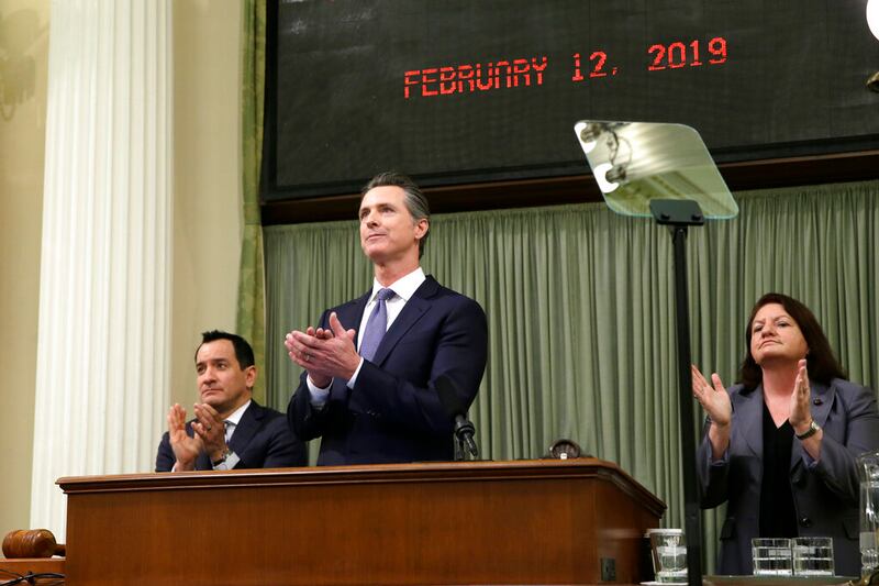 California Gov. Gavin Newsom, center, Assembly Speaker Anthony Rendon, left, and Senate President Pro Tempore Toni Atkins, right, applaud as introductions are made during Newsom’s first state of the state address at the Capitol Tuesday, Feb. 12, 2019